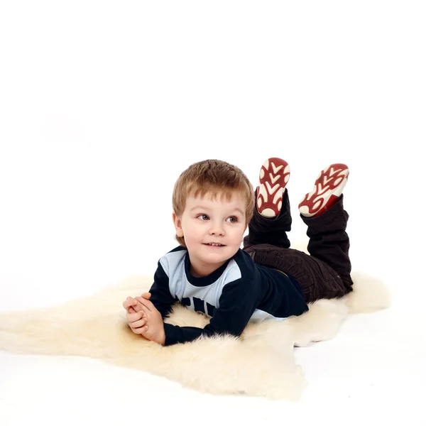 Ridendo ragazzino sdraiato sul pavimento — Foto Stock