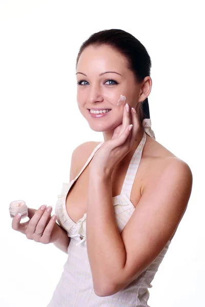 Mulher aplicando creme hidratante no rosto . — Fotografia de Stock