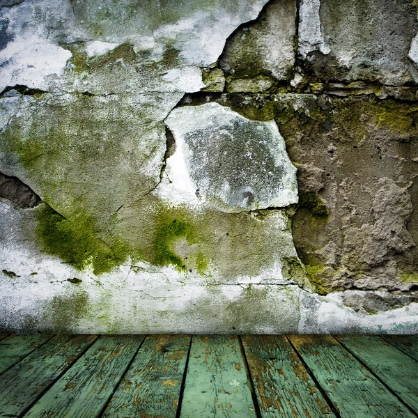 Grunge pintado pared agrietada y suelo de madera en una habitación —  Fotos de Stock