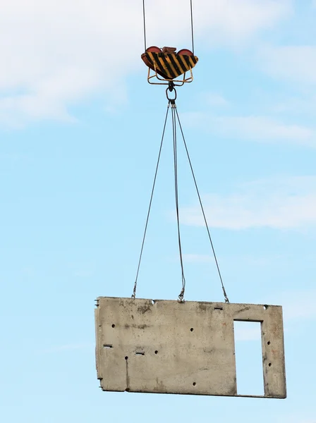 Изображение бетонного блока, поднятого башенным краном — стоковое фото
