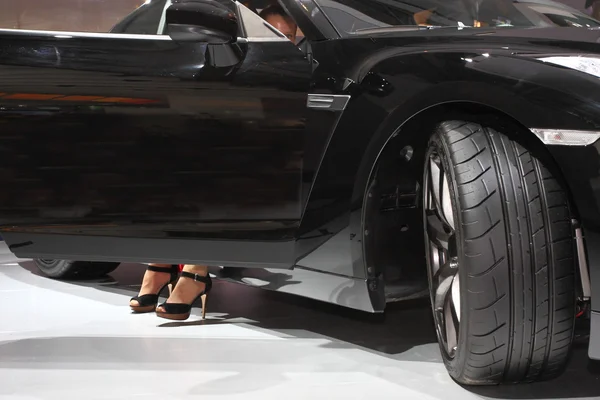 Черный автомобиль и женские ноги — стоковое фото