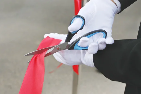 Scissors cuts the red ribbon