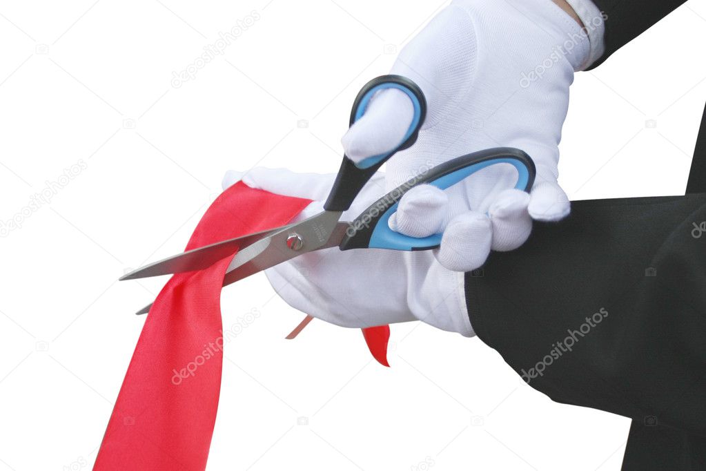 Scissors in the hand with white glove cuts the red tape