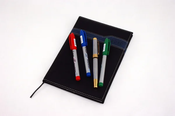 Kleur pennen op zwarte agenda — Stockfoto