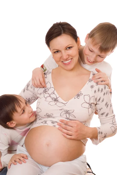 Niños abrazando a su madre embarazada —  Fotos de Stock