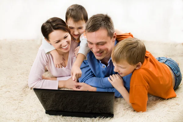 Familia mirando portátil —  Fotos de Stock