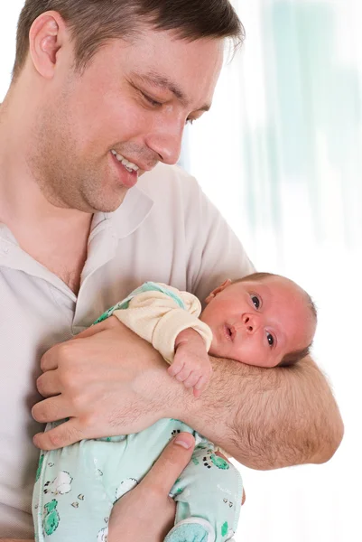 Junger Vater hält Neugeborenes zärtlich in der Hand — Stockfoto