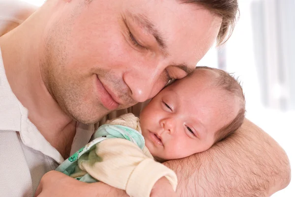 Junger Vater hält Neugeborenes zärtlich in der Hand — Stockfoto