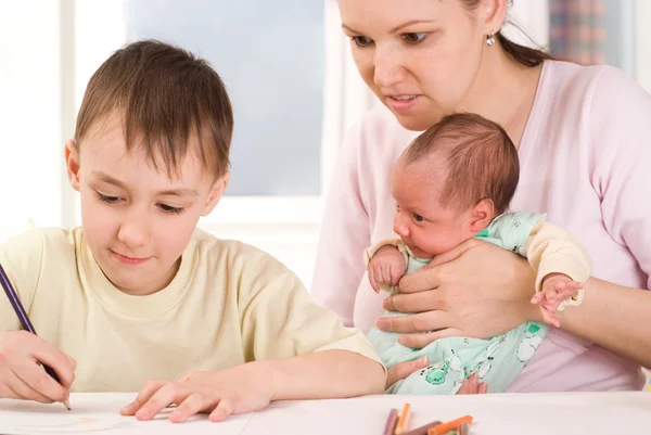 Boy draws with his mother and newborn — Stock Photo, Image