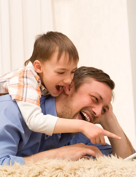 Apa és fia fekvő laptop — Stock Fotó