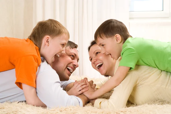 Os pais estão no tapete com filhos. — Fotografia de Stock