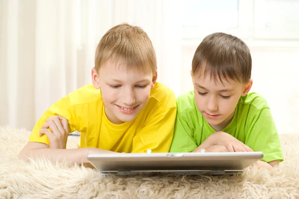 Två små bröder ligga med laptop — Stockfoto