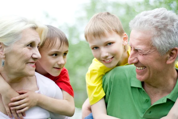 Szczęśliwa para starszych z wnukami — Zdjęcie stockowe