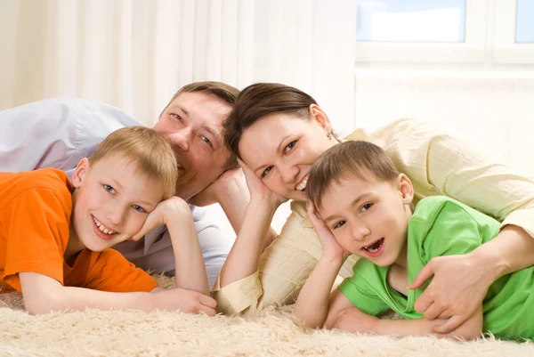 Parents are on the carpet with sons Royalty Free Stock Photos