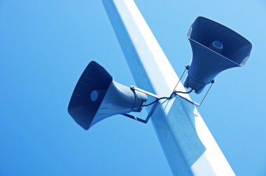 Loudspeakers on a blue sky background clipart