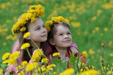 Brother and sister with dandelion garlands clipart