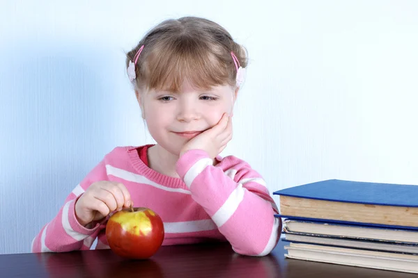 Flicka med med äpple och böcker — Stockfoto