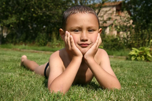 Мальчик в зеленой траве — стоковое фото