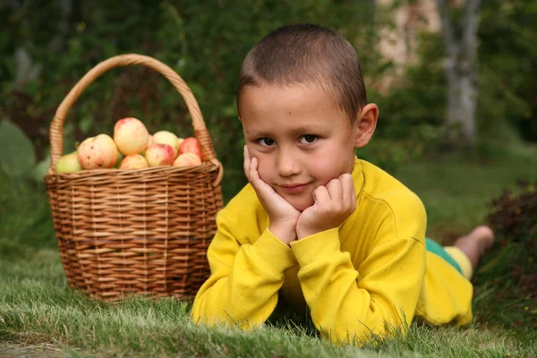 Niño posando al aire libre con manzanas — Foto de Stock