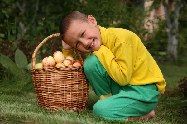 Garçon posant à l'extérieur avec des pommes — Photo