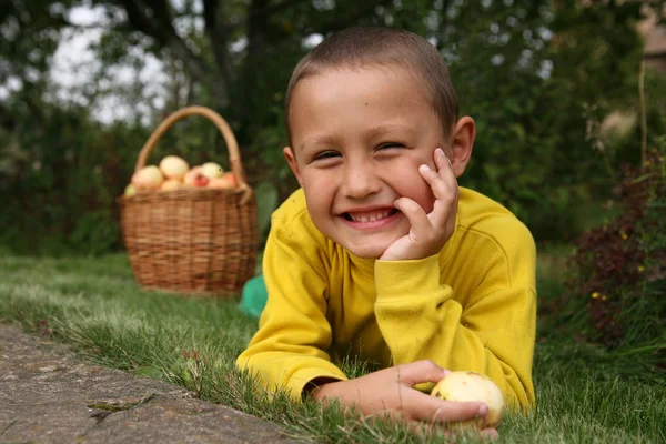 Garçon posant à l'extérieur avec des pommes — Photo