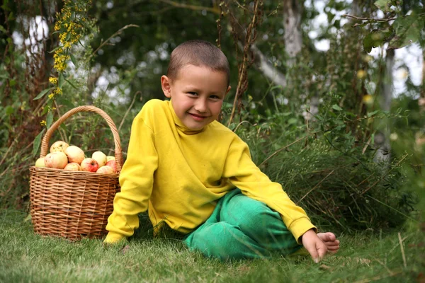 Kleiner Junge posiert draußen mit Äpfeln — Stockfoto