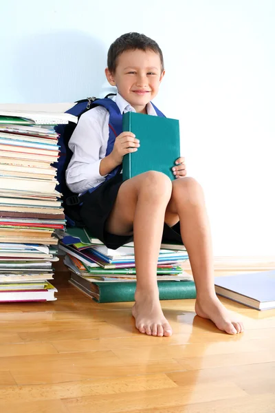 Školák na hromadu knih — Stock fotografie