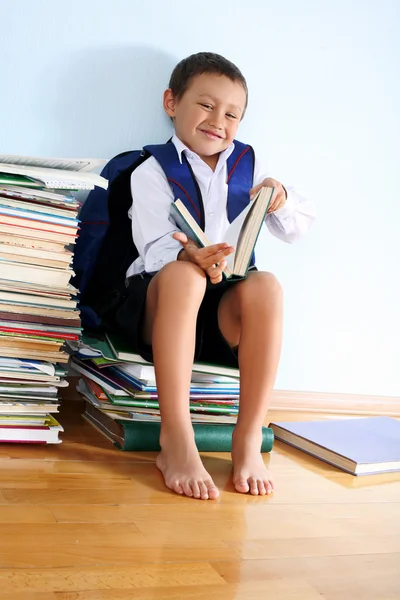 Uczeń na stercie książek — Zdjęcie stockowe