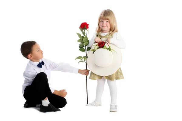 Kleine jongen met rose en meisje — Stockfoto