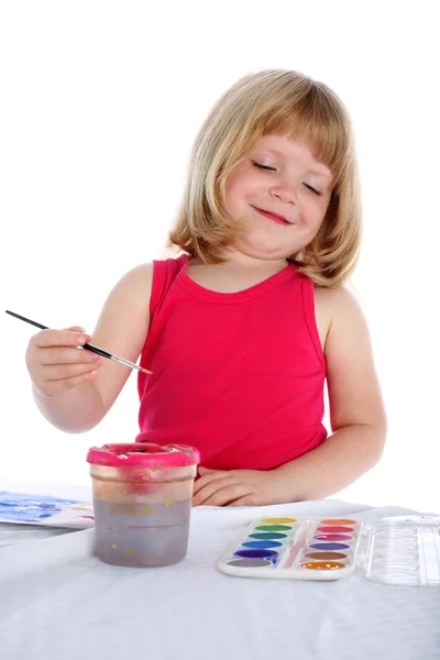 Dívka s barvou vedle stolu — Stock fotografie