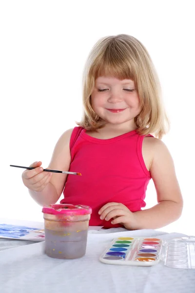 Dívka s barvou vedle stolu — Stock fotografie