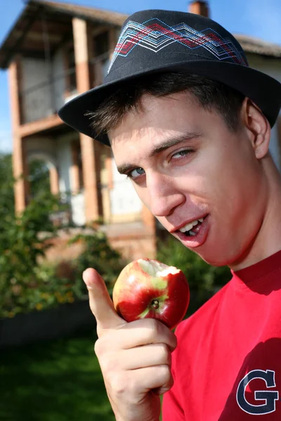 Mann mit Apfel neben sich neues Haus — Stockfoto