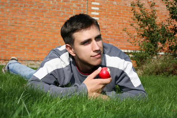 Homem com maçã ao lado da parede de tijolo — Fotografia de Stock