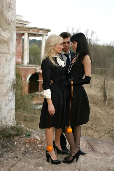 Ciúme - duas meninas com laranjas e homem — Fotografia de Stock