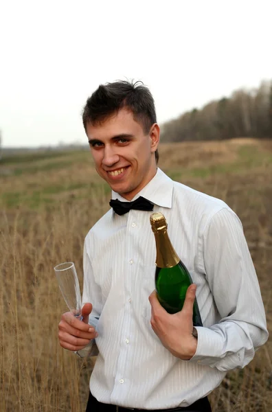 Молодий чоловік зі склянкою і пляшкою — стокове фото