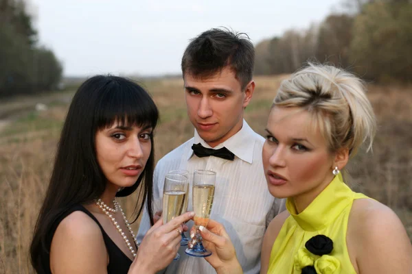Twee meisje en man met wijn buitenshuis — Stockfoto