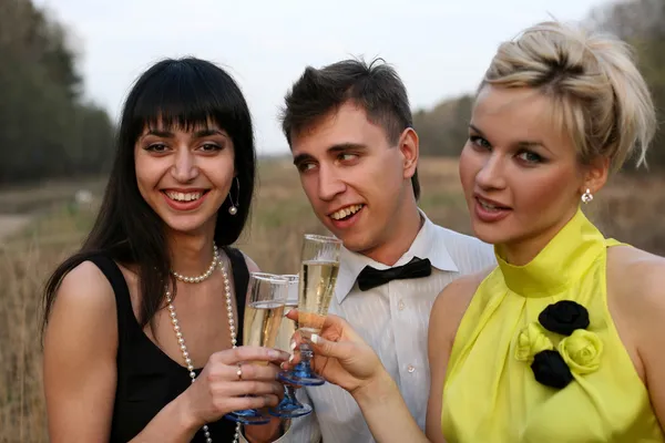 Dos chicas y un hombre con vino al aire libre — Foto de Stock