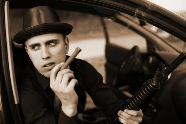 Mannen i bilen med cigarr och gevär — Stockfoto