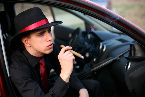 Man in auto met sigaar en geweer — Stockfoto