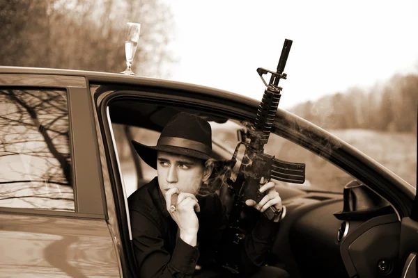 Hombre en coche con cigarro y rifle — Foto de Stock