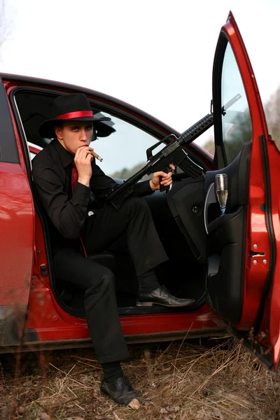 Homme en voiture avec cigare et fusil — Photo