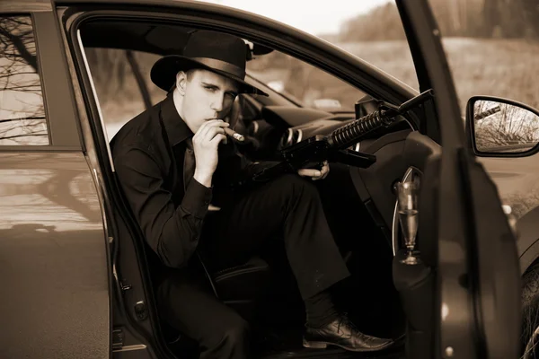 Uomo in auto con sigaro e fucile — Foto Stock