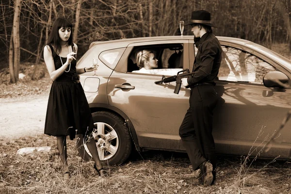 Duas meninas, carro e homem com rifle — Fotografia de Stock