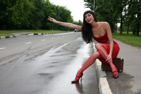 Hitch-hiking girl in the road — Stock Photo, Image