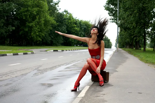 Hitch-hiking girl in the road — Stock Photo, Image