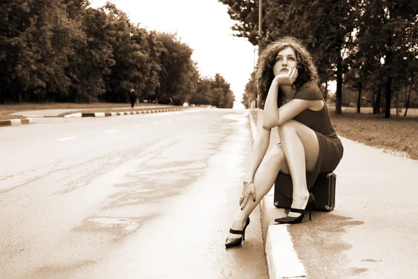 Tramper-Mädchen sitzt auf Koffer — Stockfoto
