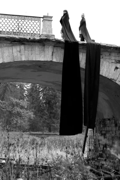 Девушки с тканями в старом мосту — стоковое фото