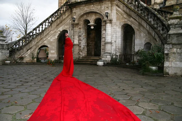 Принцесса у старого замка в красном — стоковое фото