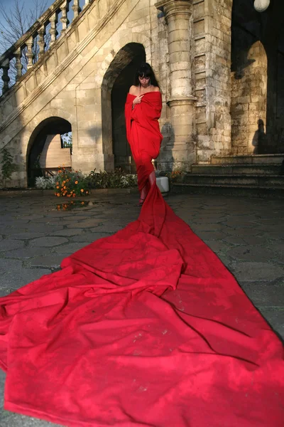 Princess beside old castle in red fabric — Stock Photo, Image