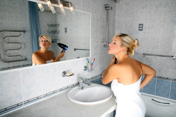 Kız banyoda kurutucu ile — Stok fotoğraf
